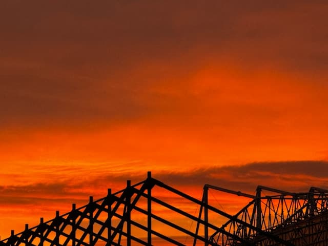 The roof of St James Park against an orange sky.